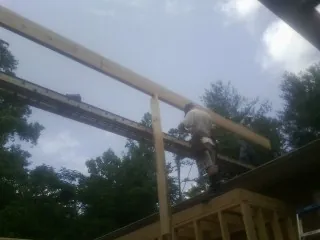 Carpenter setting a ridge beam over a new addition frame — Ice Dam Removal by Roofing Brothers in Sewaren