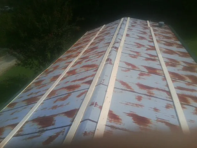 Rusted metal roof panels with new wood purlins before replacement — Storm Damage Roof Repair in Sewaren by Roofing Brothers