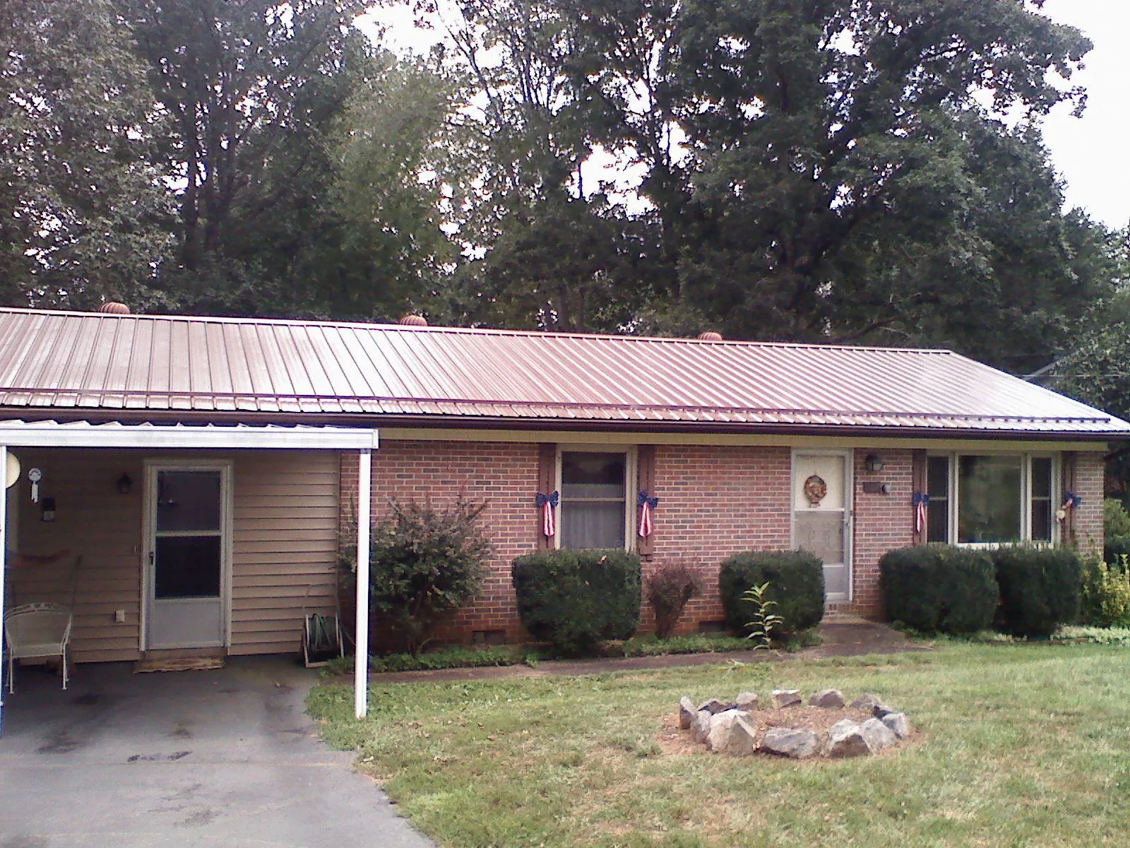 Bronze metal roof and carport on a brick ranch home — Roof Repair work by our crew in Sewaren